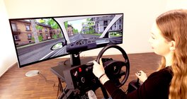 Junge Frau sitzt am Vogel Simulator kompakt