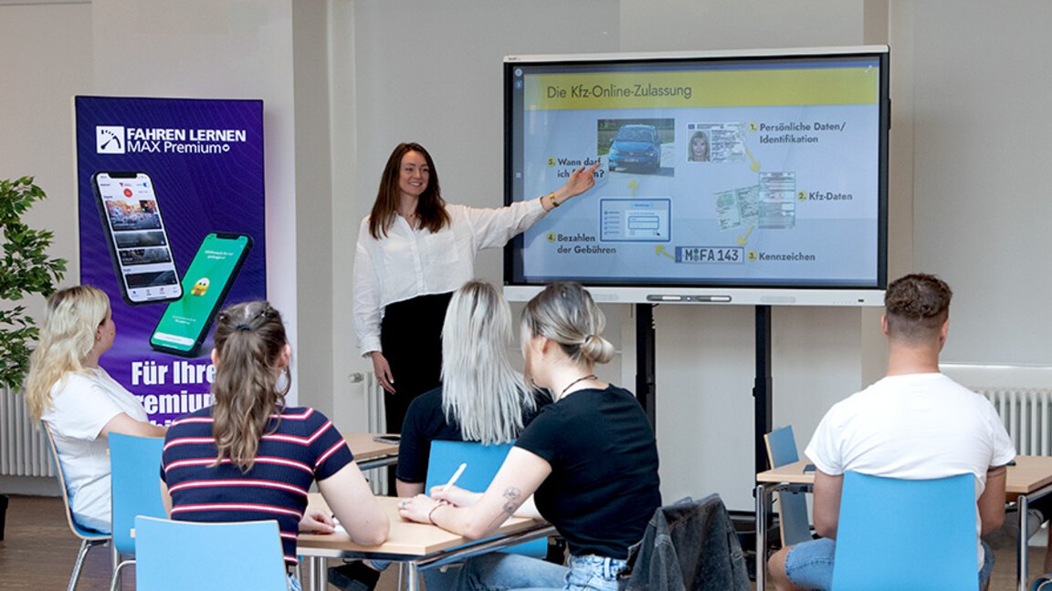Fahrlehrerin hält Unterricht vor Schülern mit einem SMART Board auf dem die Software PC Professional läuft